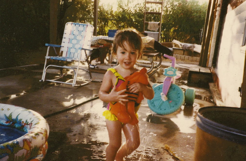 Toddler in swimsuit with big wheel