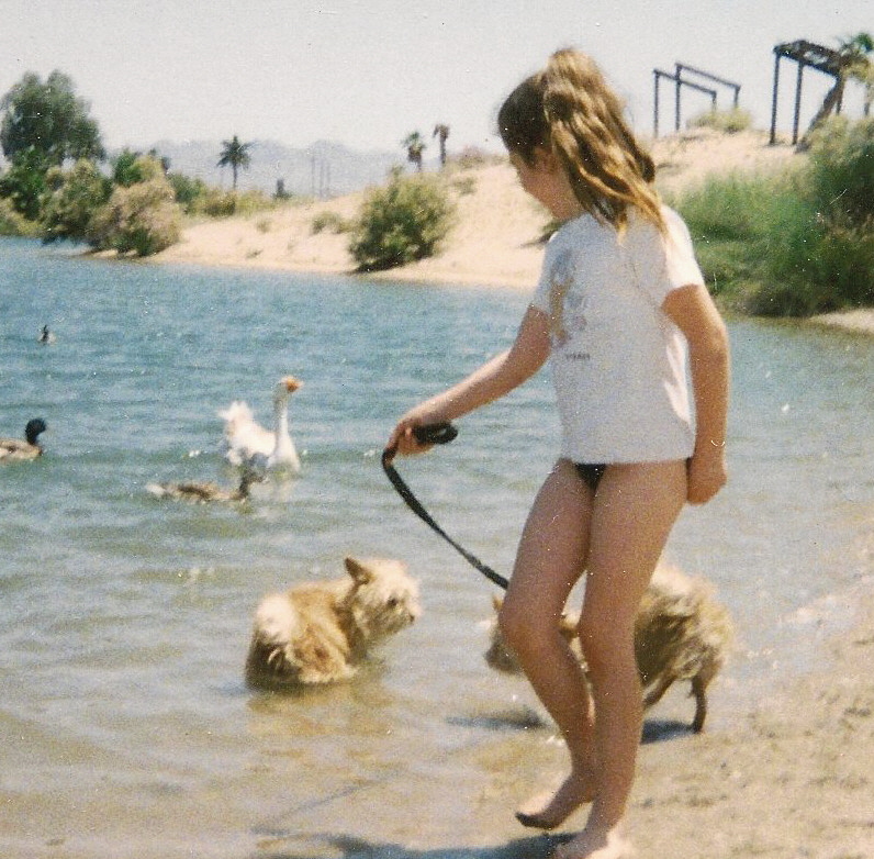 Little girl with her dogs near water