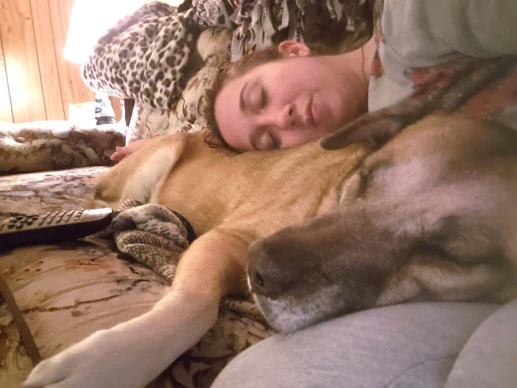 Girl and her dog sleeping on a couch